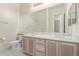 Bright bathroom featuring double sinks with oak cabinets and a large mirror reflecting the shower at 18 E Paint Your Wagon Trl, Phoenix, AZ 85085