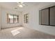 Sunny bedroom with a ceiling fan, three windows offering outdoor views, and soft carpeting at 18 E Paint Your Wagon Trl, Phoenix, AZ 85085