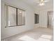 Bright, carpeted bedroom with fan, two windows, and an open door to another room at 18 E Paint Your Wagon Trl, Phoenix, AZ 85085