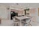Kitchen with an island featuring a breakfast bar, black appliances, light wood cabinetry and tile floors at 18 E Paint Your Wagon Trl, Phoenix, AZ 85085