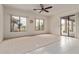 Bright living room featuring neutral carpet, tile accents, ceiling fan, and access to the covered patio at 18 E Paint Your Wagon Trl, Phoenix, AZ 85085