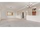Open-concept living room with neutral carpet, chandelier and view to front door at 18 E Paint Your Wagon Trl, Phoenix, AZ 85085