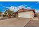 A single-story home has a two-car garage and a large driveway with desert landscaping at 1857 S El Marino Cir, Mesa, AZ 85202