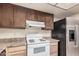 Kitchen features laminated countertops, dark cabinets, a stainless steel refrigerator, and white appliances at 1857 S El Marino Cir, Mesa, AZ 85202