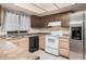 Kitchen features laminated countertops, dark cabinets, a stainless steel refrigerator, and white appliances at 1857 S El Marino Cir, Mesa, AZ 85202