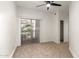 An empty bedroom with a fan, carpet flooring, access to a sliding door and a small closet at 2019 E Campbell Ave # 110, Phoenix, AZ 85016