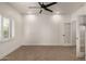 A simple bedroom with a ceiling fan, carpet flooring, and natural sunlight from a large window at 2019 E Campbell Ave # 110, Phoenix, AZ 85016