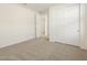 Bright bedroom with neutral carpet, large closet, and doorway leading to another room at 20319 N 224Th Dr, Surprise, AZ 85387