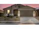Attractive single Gathering home with a two-car garage and desert landscaping in twilight at 20319 N 224Th Dr, Surprise, AZ 85387