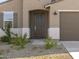 Inviting entryway with a classic front door, desert landscaping, and covered porch at 20319 N 224Th Dr, Surprise, AZ 85387