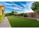 Spacious backyard with artificial turf, mature landscaping, brick accents, and a built-in stage at 21408 S 224Th Pl, Queen Creek, AZ 85142
