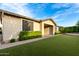 Lush backyard features artificial grass, mature bushes, and a charming brick patio perfect for outdoor entertaining at 21408 S 224Th Pl, Queen Creek, AZ 85142