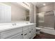Bathroom featuring a double vanity, large mirror, and a tiled shower with glass door at 21408 S 224Th Pl, Queen Creek, AZ 85142