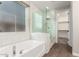 Bright bathroom features a drop-in tub, glass enclosed shower, and a view to the walk-in closet at 21408 S 224Th Pl, Queen Creek, AZ 85142