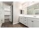 Bright bathroom showcasing double vanity with white cabinets, wood-style floors, and walk-in closet at 21408 S 224Th Pl, Queen Creek, AZ 85142