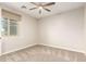 This bedroom features neutral-toned walls, plush carpeting, a ceiling fan and natural light at 21408 S 224Th Pl, Queen Creek, AZ 85142