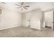 A neutral bedroom features plush carpeting and a ceiling fan, leading to the bathroom and hall at 21408 S 224Th Pl, Queen Creek, AZ 85142