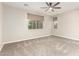 Large bedroom featuring neutral carpeting, a ceiling fan, and large windows with window coverings at 21408 S 224Th Pl, Queen Creek, AZ 85142