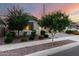 Landscaped front yard featuring mature trees, low shrubs, decorative rock, and a paved walkway leading to the home at 21408 S 224Th Pl, Queen Creek, AZ 85142