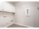 This laundry room has upper cabinets and tile floor at 21408 S 224Th Pl, Queen Creek, AZ 85142