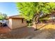 Tranquil backyard with stone landscaping, shade from a mature tree, and block fence at 2315 W Beverly Rd, Phoenix, AZ 85041