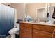 Bathroom featuring a toilet, single sink vanity, and a shower behind a curtain, designed for functionality and style at 2315 W Beverly Rd, Phoenix, AZ 85041