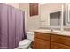 Well-lit bathroom featuring a wood vanity, neutral countertops, and a shower with a curtain at 2315 W Beverly Rd, Phoenix, AZ 85041
