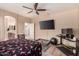 This bedroom features a large TV, ceiling fan, dog bed, and ensuite bathroom, providing comfort and convenience at 2315 W Beverly Rd, Phoenix, AZ 85041