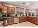 Kitchen with wooden cabinets, stainless steel dishwasher, and tiled floors and countertops at 2315 W Beverly Rd, Phoenix, AZ 85041