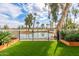Scenic backyard view overlooking a serene pond, complemented by lush landscaping and a black wrought iron fence at 2537 N Miller Rd, Scottsdale, AZ 85257