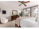 Spacious bedroom with a king bed, dresser, cozy chair, and large sliding glass doors to the patio at 2537 N Miller Rd, Scottsdale, AZ 85257