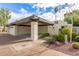 Attached two-car carport featuring desert landscaping, and a white garage door at 2537 N Miller Rd, Scottsdale, AZ 85257