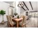 Chic dining room featuring a striking chandelier, vaulted ceilings, and a view of the living area at 2537 N Miller Rd, Scottsdale, AZ 85257