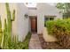 Inviting front entrance with desert landscaping, leading to a carved wood door with custom hardware at 2537 N Miller Rd, Scottsdale, AZ 85257