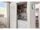 Convenient laundry area featuring white washer, dryer, storage shelves, and closet at 2537 N Miller Rd, Scottsdale, AZ 85257