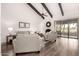 Bright living room with exposed beam ceiling, cozy seating, fireplace, and sliding glass doors at 2537 N Miller Rd, Scottsdale, AZ 85257