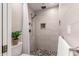Modern tiled shower with a rainfall showerhead, a hand shower, and a pebble floor at 2537 N Miller Rd, Scottsdale, AZ 85257