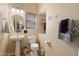 Well-lit half bathroom featuring a pedestal sink and decorative elements at 26678 N Babbling Brook Dr, Phoenix, AZ 85083
