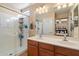 Bright bathroom featuring a double vanity, a large mirror, and a glass-enclosed shower at 26678 N Babbling Brook Dr, Phoenix, AZ 85083