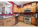 Modern kitchen featuring stainless steel appliances, warm wood cabinets, and granite countertops at 26678 N Babbling Brook Dr, Phoenix, AZ 85083