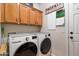 Convenient laundry room featuring front-load washer and dryer and overhead cabinets at 26678 N Babbling Brook Dr, Phoenix, AZ 85083