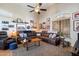 Stylish living room featuring a large sectional sofa, a ceiling fan, and tiled floors at 26678 N Babbling Brook Dr, Phoenix, AZ 85083