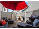 Cozy patio space with stylish furniture, chiminea, grill, and a large red umbrella at 26678 N Babbling Brook Dr, Phoenix, AZ 85083