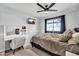 This bedroom has a light wood floor and gray duvet, also a tv and vanity area at 2924 W Anderson Dr, Phoenix, AZ 85053