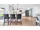 Bright kitchen with white cabinets, stainless steel appliances, island with breakfast bar, and wood flooring at 2924 W Anderson Dr, Phoenix, AZ 85053