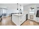 Modern kitchen with a white island, shaker cabinets, black hardware, and wood flooring at 2924 W Anderson Dr, Phoenix, AZ 85053