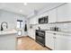Clean kitchen with white cabinetry, subway tile backsplash, modern appliances, and access to exterior at 2924 W Anderson Dr, Phoenix, AZ 85053