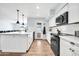 Bright, clean kitchen featuring white cabinetry, a subway tile backsplash, modern appliances, and island at 2924 W Anderson Dr, Phoenix, AZ 85053