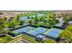 Community aerial view showcasing manicured tennis courts, golf course, lush landscaping, and serene pond for relaxation at 36145 N Desert Tea Dr, Queen Creek, AZ 85140