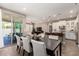 Open-concept dining area leading to the living room, kitchen, and outdoor patio with a glass door at 36145 N Desert Tea Dr, Queen Creek, AZ 85140